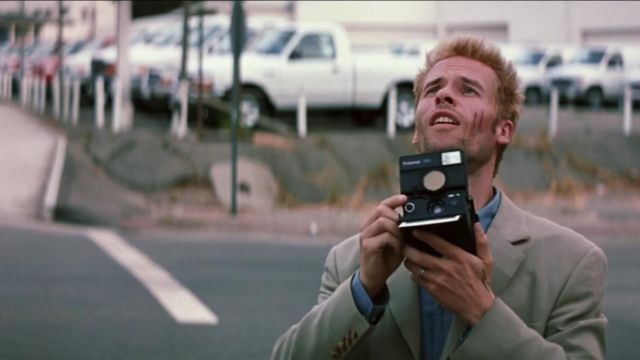 Guy Pearce as Leonard in Memento holding a Polaroid